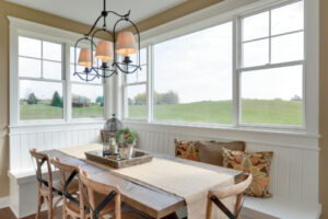 a picture window surrounded by hung windows in a dining room