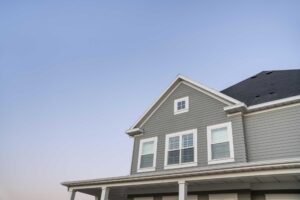 grey-colored lap siding on the upper story of a family home